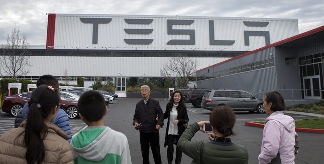 Tourists from China take photographs at the Tesla Factory complex in Fremont, Calif., on Thursday, Jan. 28, 2016. (LiPo Ching/Bay Area News Group)