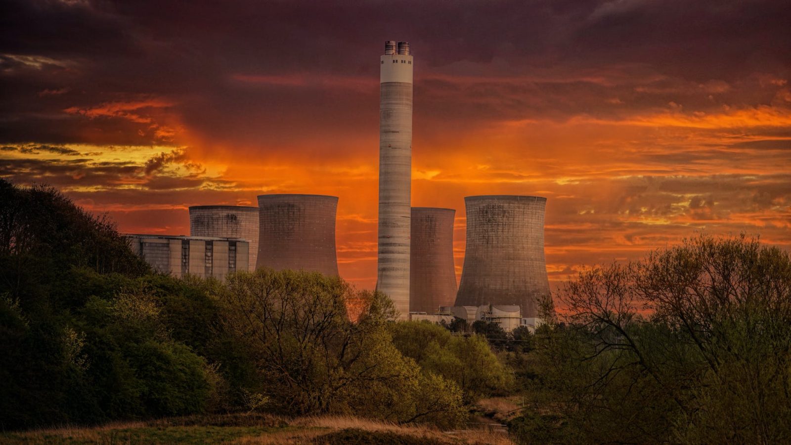 white nuclear plant silo under orange sky at sunset
